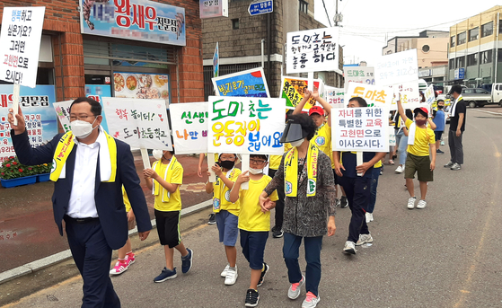 Children campaign around their neighborhood to bring new residents to their town in Namhae County in South Gyeongsang in July 2020. The demonstration took place amid rising concern over school shutdowns and village extinction. [YONHAP] 