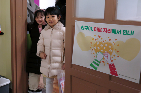 Soon-to-be grade one students enter a classroom at an elementary school in Haeundae District, Busan, on Wednesday morning to attend their pre-orientation day. [YONHAP] 
