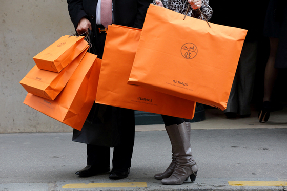 A couple leaves a Hermès store in Paris with shopping bags. Picture taken in 2013. [REUTERS/YONHAP]