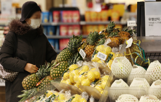 A customer shops for fruit at a supermarket in Seoul on Thursday. The government will exempt or lower tariffs for 21 types of fruit to combat skyrocketing fruit prices. Fresh fruit including bananas, pineapples, mangoes, grapefruit and avocados are on the tariff reduction list, according to the Ministry of Economy and Finance's economic policies for 2024 that was announced Thursday. [NEWS1]
