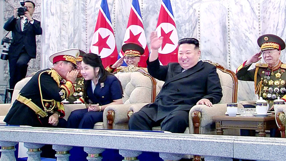 Kim Ju-ae, left, sits next to her father Kim Jong-un, incumbent leader of North Korea, during a military parade in Pyongyang in September last year. The photo was carried by the official North Korean Central News Agency (KCNA). [YONHAP]