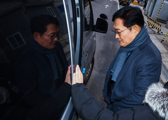 Former Democratic Party leader Song Young-gil riding the police vehicle from the Seoul Central District Court in Seocho District on Dec. 18 after his arrest warrant was reviewed. The arrest warrant was issued at midnight. [YONHAP]