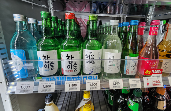 Bottles of soju are displayed at a convenience store in Seoul. Major convenience store chains including CU, GS25, 7-Eleven and Emart24 lowered their prices for the liquor by 200 to 300 won on Tuesday. [NEWS1]