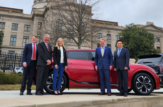 Officials from the Georgia state government and Kia including Georgia Governor Brian Kemp, second from right, and Stuart Countess, second from left, president of Kia Georgia, pose with Kia's EV6 at the automaker's manufacturing plant in Georgia on Feb. 1. [YONHAP]