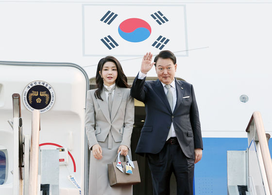 First lady Kim Keon Hee, left, and President Yoon Suk Yeol greet officials and reporters before boarding a flight to New York on Sept. 18, 2023. [YONHAP]