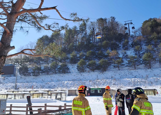 Rescue crews and first responders observe the scene of a gondola lift malfunction that stranded 64 skiers on Sunday morning in Pyeongchang County, Gangwon. All skiers made their way out safely after being stuck inside for more than 30 minutes. [YONHAP]