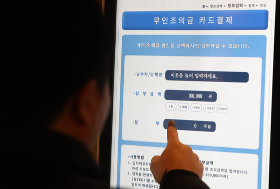 A person uses an unmanned kiosk to send his condolence money at a funeral in Seoul on Sunday. People can now use kiosks to send their condolence money with credit cards without separately withdrawing cash from ATMs. The new digital system also allows people to set interest-free installment plans for the money. [YONHAP]