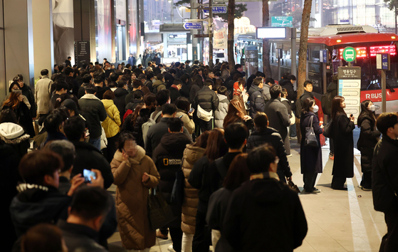 A crowd of people wait in line to take their buses back home at Myeong-dong in Jung District, central Seoul on Thursday. [YONHAP] 
