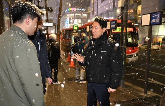 Seoul Mayor Oh Se-hoon, right, visits the intercity bus stop area located at Myeong-dong in downtown Seoul on Saturday after the city government's installation of bus stop signs in the area caused traffic chaos. [SEOUL METROPOLITAN GOVERNMENT] 