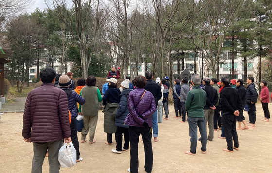 Participants listen to ″Walking barefoot movement″ community founder and head Park Dong-chang's lecture on the benefits of earthing at a barefoot walking training session held on Dec. 9. [KIM JU-YEON]