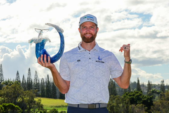 Chris Kirk celebrates with the trophy after winning the final round of The Sentry at Plantation Course at Kapalua Golf Club in Kapalua, Hawaii on Sunday. [GETTY IMAGES]