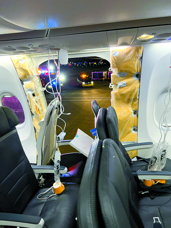 Passenger oxygen masks hang from the roof next to a missing window and a portion of a side wall of an Alaska Airlines Flight 1282, which had been bound for Ontario, California and suffered depressurization soon after departing, in Portland, Oregon, on Friday in this picture obtained from social media. [REUTERS/YONHAP]