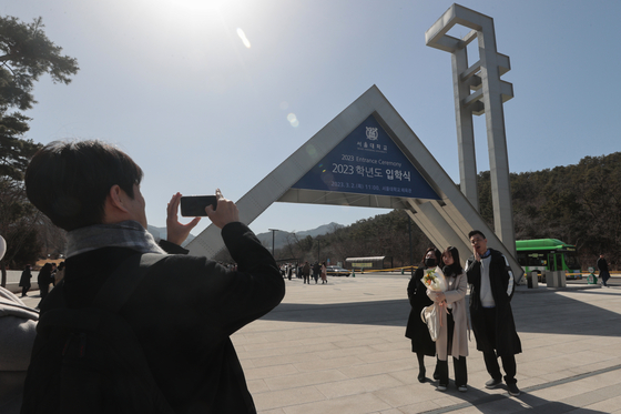 A family takes a photo in front of Seoul National University's main gate in Gwanak District, southern Seoul, during the university's matriculation ceremony in March last year. The university is planning to create a new college for undecided major students in the 2025 academic year. [YONHAP] 