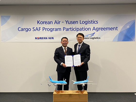 Korean Air's Senior Vice President Eum Jae-dong, right, and Eisuke Fukagawa, head of Yusen Logistics' Airfreight forwarding group, pose for a photo after signing a partnership on promoting the use of sustainable aviation fuels in Tokyo. [KOREAN AIR]