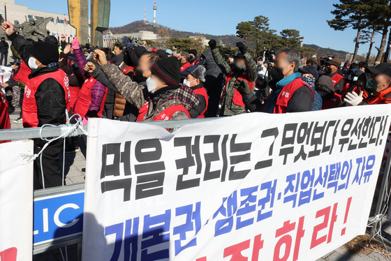 Members of an association of dog farmers protest the government's proposed dog meat ban in front of the presidential office in Yongsan, central Seoul, last November. The banner reads, ″The rights to eat is foremost!″ [YONHAP] 