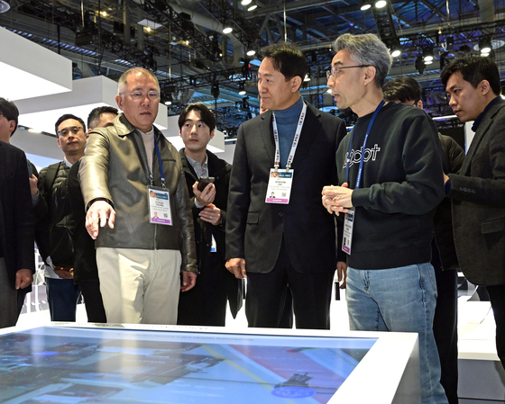 Hyundai Motor Executive Chair Euisun Chung, left, explains the company's hydrogen strategy to Seoul Mayor Oh Se-hoon, center, and 42dot CEO Song Chang-hyun, during their tour to the automaker's booth at CES 2024 in Las Vegas. [JOINT PRESS CORPS]