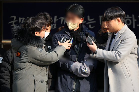 Man who attacked DP chief Lee Jae-myung answers questions while being escorted by police to the prosecutors' office in Busan on Wednesday. [YONHAP]