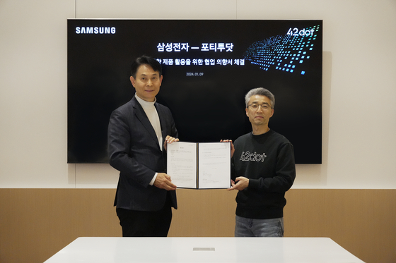 42dot CEO Song Chang-hyun, right, and Park Yong-in, head of the System LSI business at Samsung Electronics, sign an agreement on Tuesday at CES 2024 in Las Vegas. [42DOT]