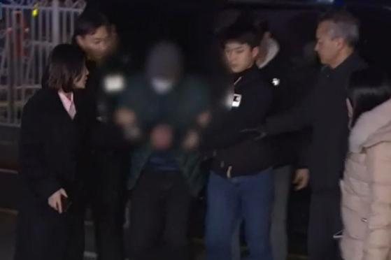 The 57 year-old suspect, who is accused of murdering two women, taken into the Ilsan Seobu Police station on Saturday. The suspect only identified by his family name Lee was caught wandering at a traditional market in Gangwon on Friday. [YONHAP]