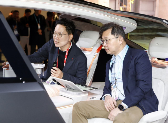 SK On's Executive Vice Chairman Chey Jae-won listens to explanation from LG Electronics' spokesperson about LG's Alpha-able concept car at CES 2024 in Las Vegas on Wednesday. [SK ON]