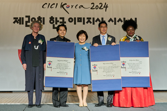Swiss Ambassador to Korea Dagmar Schmidt Tartagli, far left, Choi Jung-hwa, president of Corea Image Communication Institute, middle, and the three winners of Korea Image Awards 2024 pose for cameras at the InterContinental Seoul Coex hotel in Gangnam District, southern Seoul, on Wednesday evening. [CICI]