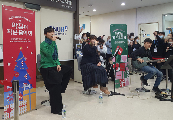 Sibling duo AKMU performs at Seoul National University Hospital, located in Jongno District, central Seoul, on Tuesday for pediatric patients. [YONHAP]