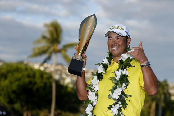 Hideki Matsuyama celebrates with the trophy after winning in a one-hole playoff against Russell Henley of the United States during the final round of the Sony Open in Hawaii at Waialae Country Club on Jan. 16, 2022 in Honolulu, Hawaii. [GETTY IMAGES]