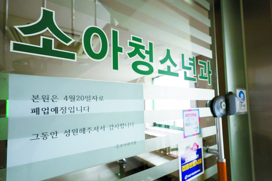 A pediatric clinic in Seoul discontinued its business in May 2023. A notice saying the clinic is permanently shut down is attached to the door. [YONHAP] 