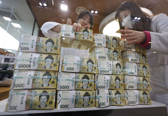 Employees at the Hana Bank Counterfeiting and Forgery Response Center in Jung District, central Seoul, organize stacks of 50,000 won ($40) banknotes on Monday. The percentage of 50,000 won banknotes returned to the central bank compared to those issued reached 67.1 percent last year, nearly matching the record high of 67.4 percent in 2018, according to the Bank of Korea on Monday, indicating robust cash circulation in the economy. [YONHAP] 