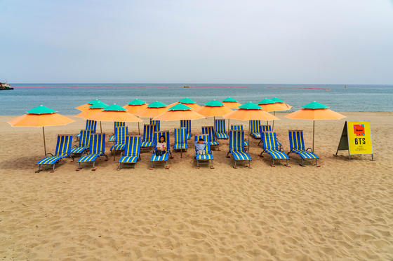 People lie on sunbeds at Maengbang Beach in Samcheok, Gangwon, a site made famous for being featured in boy band BTS's album ″Butter″ (2021). [JOONGANG PHOTO]