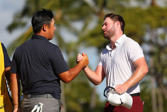 An Byeong-hun, left, and Grayson Murray shake hands on the 18th green during the final round of the Sony Open in Hawaii at Waialae Country Club in Honolulu, Hawaii on Sunday.  [GETTY IMAGES]