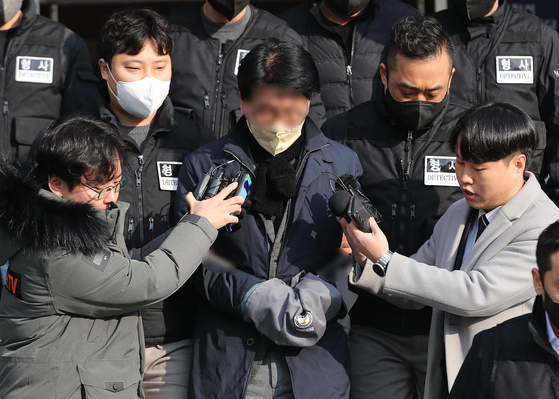 The assailant, surnamed Kim, center, speaks to reporters at Yeonje Police Station in Busan on Wednesday morning as he is escorted by police to be transferred to the prosecution for charges of attempted murder after stabbing Democratic Party Chairman Lee Jae-myung last week. [NEWS1]