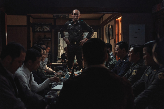 A scene from the film "12.12: The Day" shows military leader Chun Doo-kwang, center, played by actor Hwang Jung-min, talking to the members of hanahoe, an unofficial private society of military officers. [PLUS M ENTERTAINMENT] 