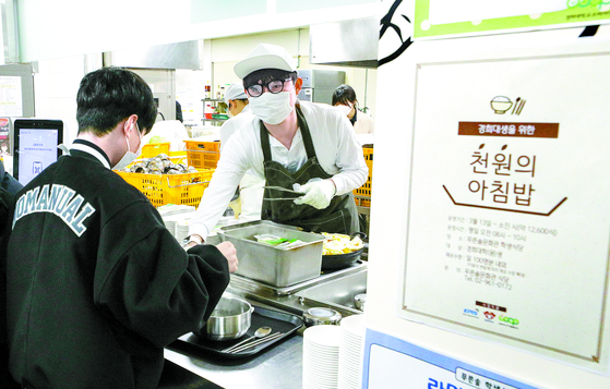 A student lines up for a 1,000-won breakfast at Kyung Hee University's cafeteria in Dongdaemun District, eastern Seoul, in March last year. [NEWS1]