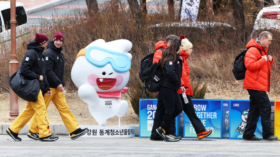 Athletes competing at the Gangwon 2024 Winter Youth Olympics walk past mascot “Moongcho″ at the Olympics village Gangneung-Wonju National University in Gangneung, Gangwon on Thursday. [NEWS1]