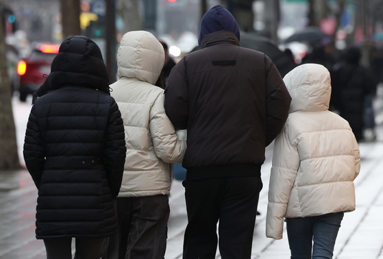 Passersby in puffers walk the streets of Jongno District, downtown Seoul, on Sunday afternoon. The Korea Meteorological Administration (KMA) issued a cold wave advisory in Seoul for 9 p.m. Sunday for the first time this year. [NEWS1] 