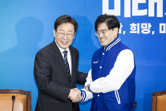 Democratic Party chief Lee Jae-myung, left, shakes hands with Kong Young-woon, former president of Hyundai Motor after announcing his join to the conservative party Monday morning. [NEWS1]