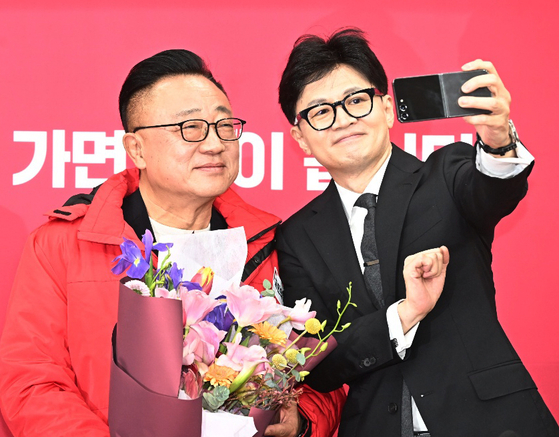 Han Dong-hoon, right, interim leader of the main People Power Party, takes a selfie with Koh Dong-jin, former CEO of Samsung Electronics' smartphone business, at a recruitment ceremony on Monday. [NEWS1] 