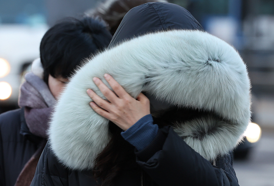 Bundled-up passersby walk in the streets of Jongno District, downtown Seoul, as morning lows in the capital dipped to as low as minus 14 degrees Celsius (6.8 degrees Fahrenheit) on Tuesday morning. [NEWS1]