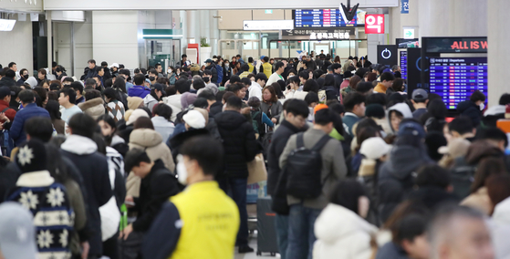 Stranded travelers crowd Jeju International Airport on Tuesday morning as flights were canceled due to heavy snow and gusts in the area. [NEWS1]