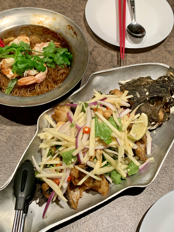 Glass noodle pot with shrimp, left, and fried fish with sour apple salad at Yeong Dong Pochana in Gangnam District, southern Seoul [LEE JIAN]