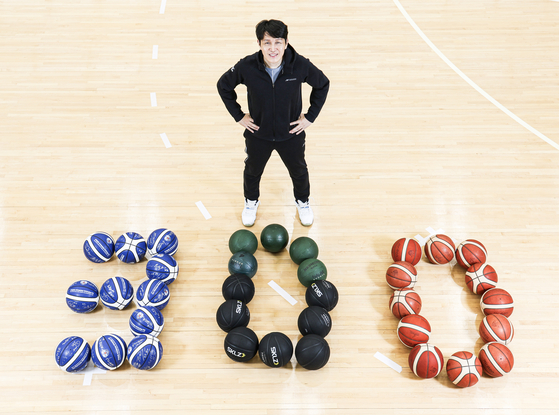 Asan Woori Bank Woori Won head coach Wie Sung-woo poses for a photo with basketballs shaped in 300 at the team's training center in Seongbuk District, central Seoul on Jan. 9. [JOONGANG ILBO] 