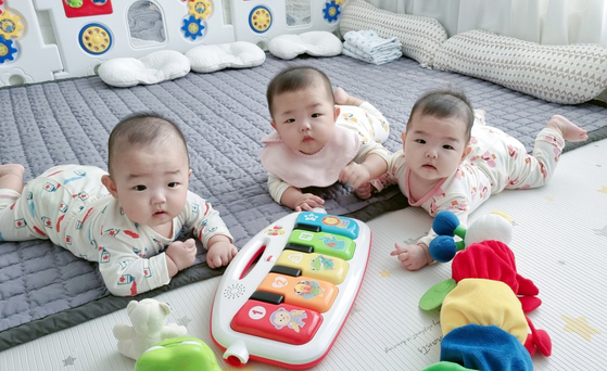 Kim's triplets play with toys at their home in Gangjin County, South Jeolla. [HWANG HEE-KYU / JOONGANG PHOTO]