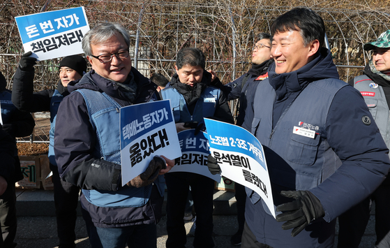 Jin Kyung-ho, the head of the Delivery Workers’ Union, left, shares smiles following the appellate court’s decision that upheld the characterization of CJ Logistics‘ refusal to participate in collective talks with delivery workers as “unfair labor practices” in front of the Seoul High Court on Wednesday. [YONHAP]