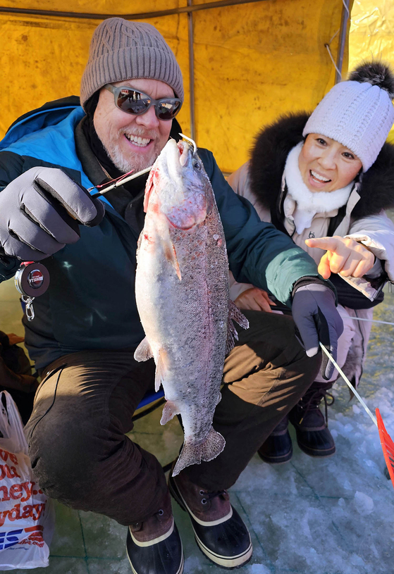  Visitors hold a trout they caught at the Pyeongchang Trout Festival. [NEWS1]