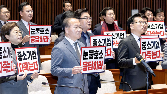 People Power Party lawmakers chant, calling for an extension of the grace period of the Serious Accident Punishment Act on small businesses with fewer than 50 employees, holding signs that read ″Small businesses will all be gone,″ and ″Respond to the [small businesses'] teary pleas,″ during the party's general meeting on Thursday at the National Assembly in western Seoul. [JUN MIN-KYU]