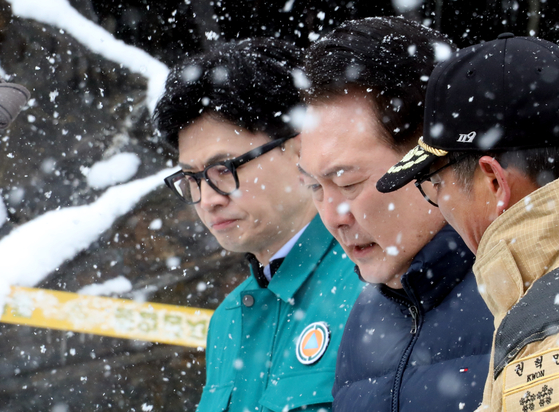 People Power Party interim leader Han Dong-hoon, left, and President Yoon Suk Yeol visits a traditional market in South Chungcheon onTuesday. The market was destroyed from  a fire that happened the previous night. [YONHAP] 