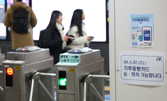 Commuters at Seoul Station in central Seoul on Sunday walk past a sign showing that Seoul’s Climate Card, an unlimited transit pass aimed at reducing pollution in the city by encouraging people to use more public transportation, has been implemented since Saturday. The Seoul Metropolitan Government said that around 71,000 people used the Climate Card on the first day of its launch. Commuters can pay around 65,000 won ($48) per month for these passes to use subways, buses and public bicycles without limits. [YONHAP]