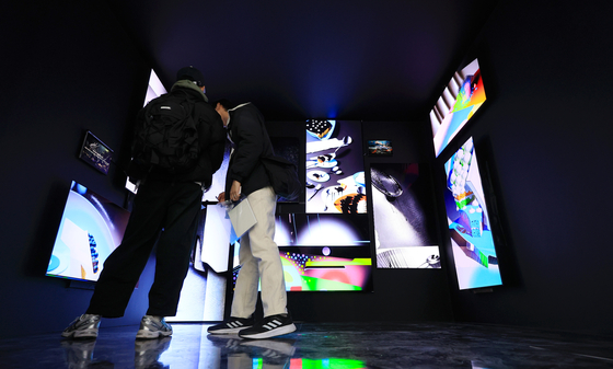 Visitors watch a media art exhibition titled “Touch the Real” at News Museum in Euljiro, central Seoul, on Sunday. Samsung Display, Samsung Electronics and Intel Korea are showcasing their latest OLED (organic light-emitting diode) technology in the free exhibition that runs until Feb. 12. [YONHAP]
