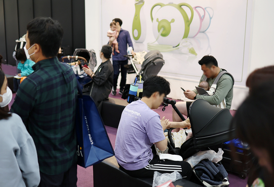 Fathers tend to their babies at a baby fair took place at Coex in Gangnam District, southern Seoul, in October last year. [YONHAP]